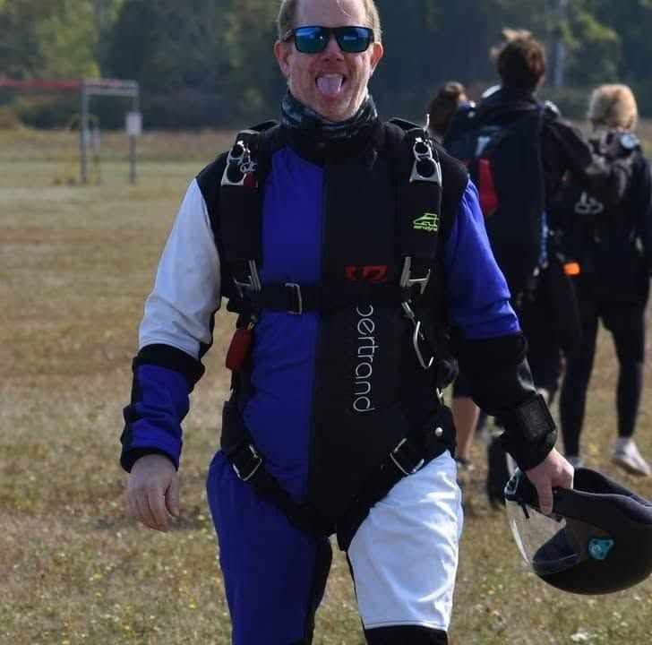 The committee, all of him, walking off the landing area with helmet in hand