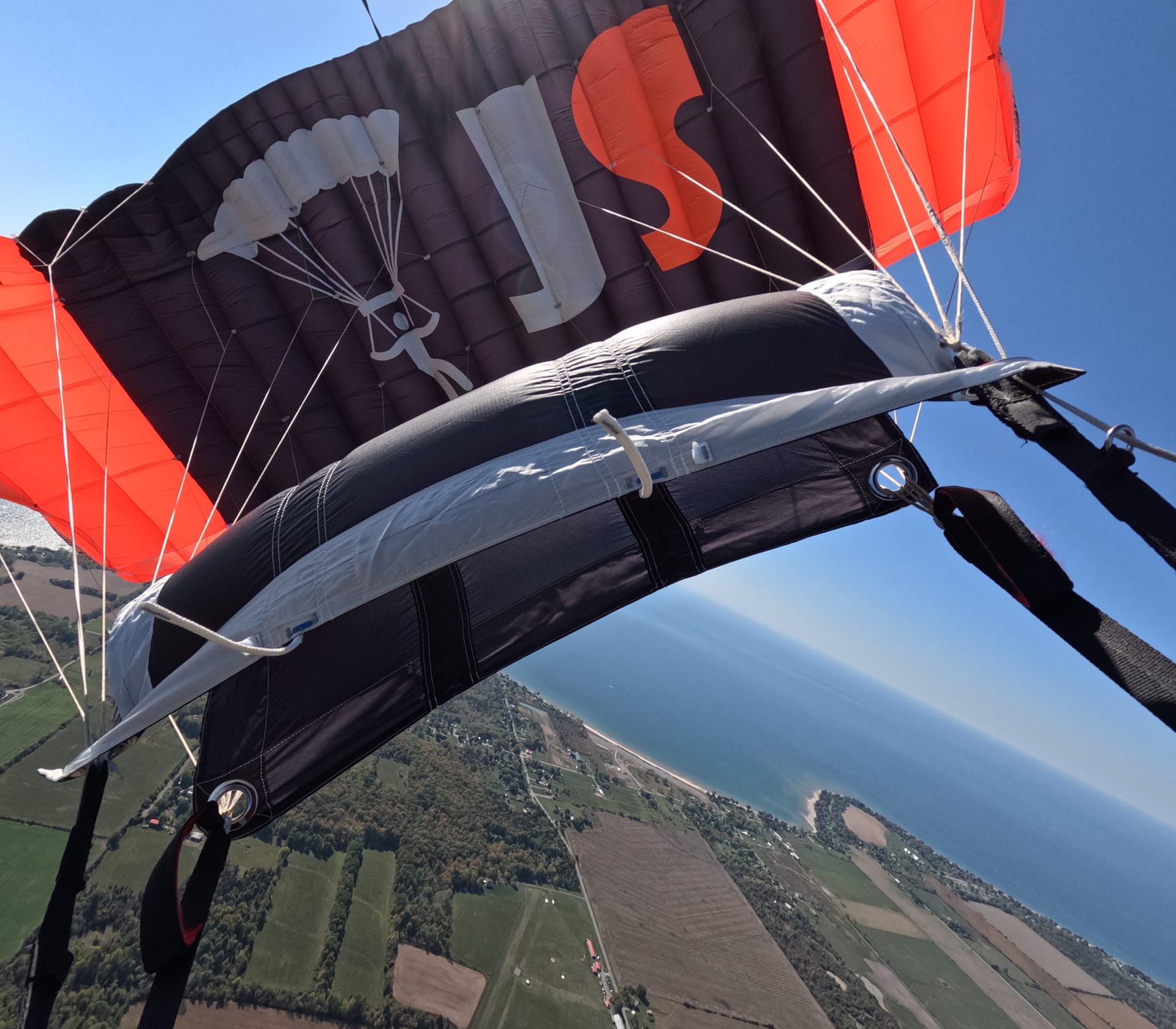 Jump Slut branded canopy in flight over farmland and shoreline — the boogie's only confirmed sighting